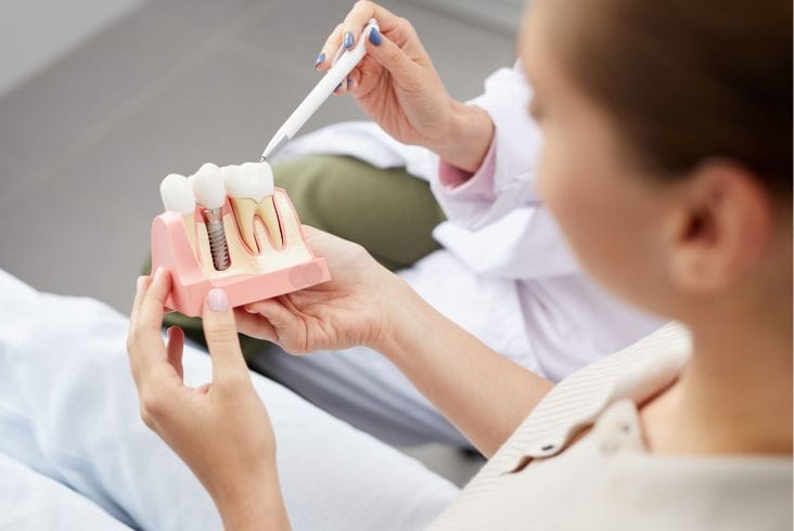 Imagine cu un pacient intr-o clinica dentara - Știri de azi Știri de azi | Implant dentar: Soluția modernă pentru o viață sănătoasă și încrezătoare | City Dent - Știri de azi | Medicul specialist în implantologie la City Dent explicand cum arata un implant dentar