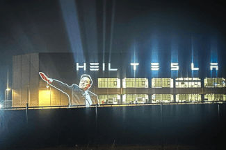 Știri de azi | Activişti germani de la ”Centrul de Frumuseţe Politică” denunţă salutul lui Musk proiectându-l pe fabrica Tesla de lângă Berlin. ”Cumpăraţi o Tesla, susţineţi fascismul!”. ”Vrem să organizăm distrugerea lui Elon Musk în mod artistic” - Știri de azi | 