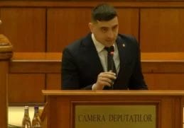 George Simion adresându-se Parlamentului din România, exprimându-și nemulțumirea față de conducerea guvernamentală, în timp ce stă la pupitrul Camerei Deputaților.