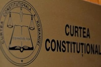 Știri de azi | Ședință crucială a CCR, de la ora 13.00: se decide soarta alegerilor - Știri de azi | Sigla Curții Constituționale a României pe un fond de placă metalică, simbolizând gravitatea și importanța deciziilor instanței supreme în contextul electoral