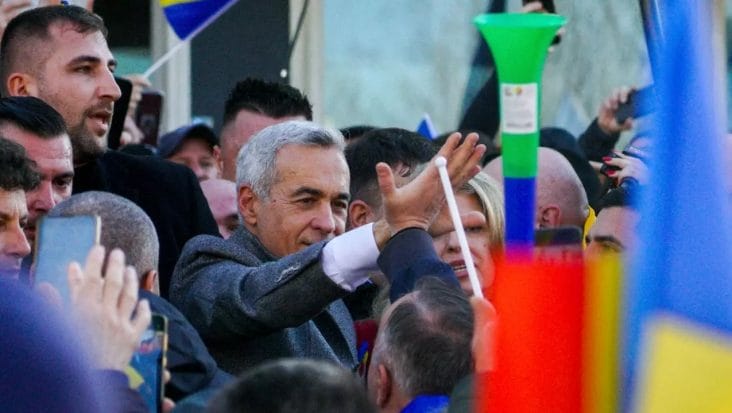 Călin Georgescu înconjurat de susținători în timpul unei manifestații pentru democrație, reflectând spiritul unității și dorința de schimbare în România.