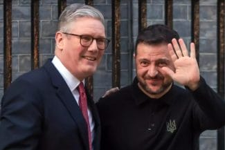 Știri de azi | Zi de foc pentru viitorul Europei. Summit la Londra, pe tema apărării. Ilie Bolojan, la masă cu mai marii bătrânului continent - Știri de azi | Premierul britanic Keir Starmer alături de președintele ucrainean Volodimir Zelenski, zâmbind și salutând, în timpul unei întâlniri la Londra