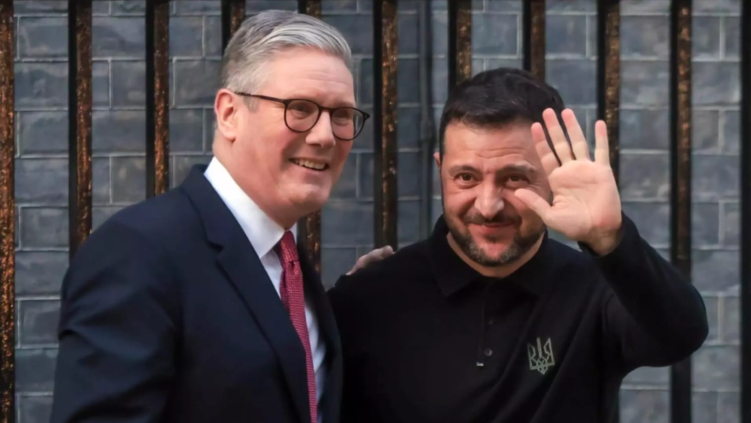 Premierul britanic Keir Starmer alături de președintele ucrainean Volodimir Zelenski, zâmbind și salutând, în timpul unei întâlniri la Londra