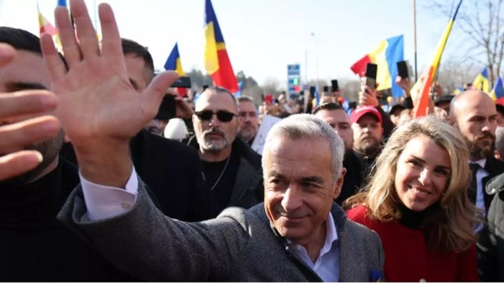 calin georgescu salutand multimea - Știri de azi Știri de azi | Semnăturile lui Călin Georgescu sunt pefect valabile – SURSE. 40 de oameni se ocupă de verificare. Ședință cruciala la BEC, la ora 18:00. – LIVE TEXT - Știri de azi | Călin Georgescu salută susținătorii în timpul unui miting, cu multitudine de steaguri românești în fundal